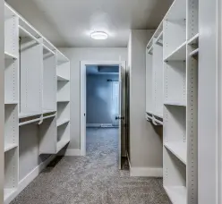 Walk-in closet with white built-in shelving and hanging rods