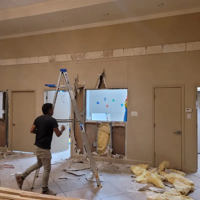 Worker demolishing a wall during a renovation project